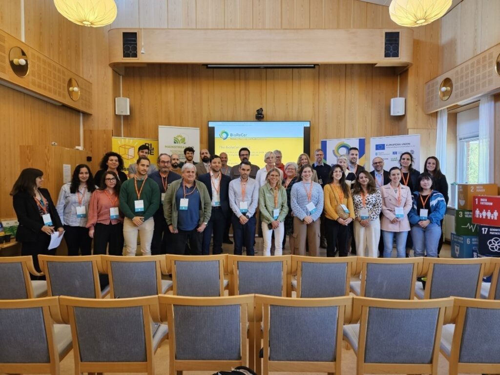Group picture of the BioReCer stakeholders in a lecture hall at RISE in front of a screen and roll-up banners following the BioReCer graphical ID and showcasing the logo.